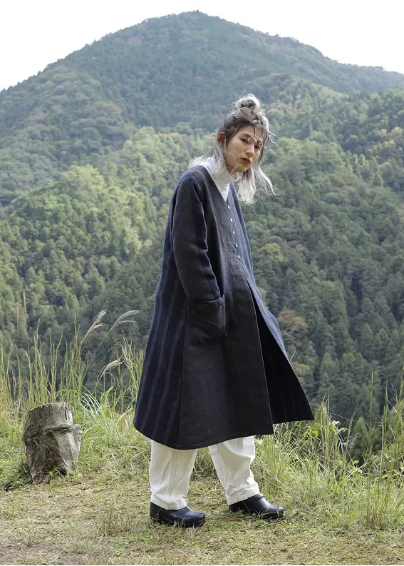 山の風景の中で播州織のコートを着た女性
